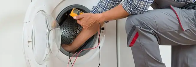Dryer repair technician inspecting and repairing a clothes dryer in Nashville, TN
