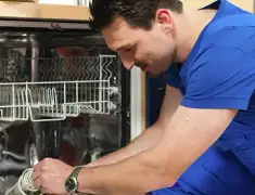 Dishwasher repair technician inspecting and servicing an open dishwasher in Nashville, TN