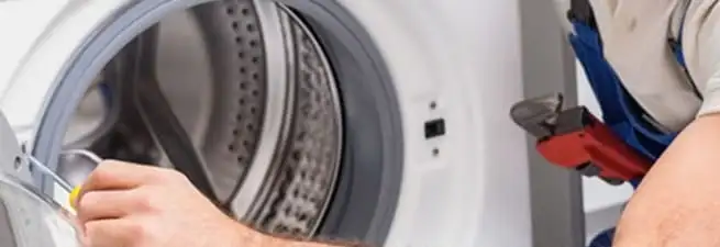 Appliance technician repairing a clothes dryer drum and internal parts in Nashville, TN