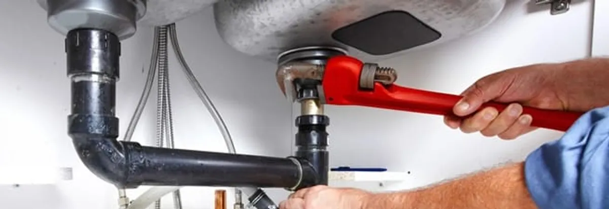 Garbage disposal repair technician tightening the sink drain and disposal connection in Nashville, TN
