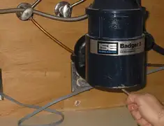 Garbage disposal repair technician tightening the mounting ring under a sink in Nashville, TN