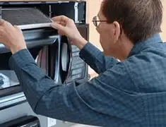 Appliance repair technician replacing a microwave vent filter in Nashville, TN
