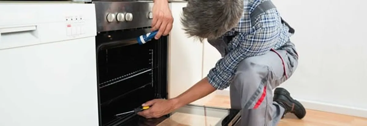 Oven repair technician inspecting and servicing an electric oven in Nashville, TN