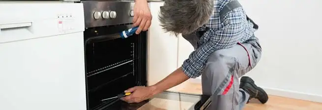 Oven repair technician inspecting and servicing an electric oven in Nashville, TN