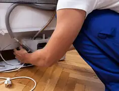 Appliance repair technician fixing refrigerator water line and connections in Nashville, TN