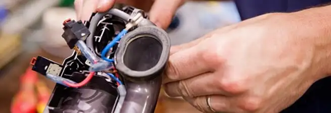 Vacuum repair technician reconnecting wiring and components in Nashville, TN