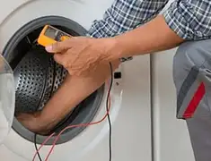 Washing machine repair technician testing a front-load washer with diagnostic tools in Nashville, TN