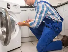 Washing machine repair technician servicing a front-load washer in Nashville, TN