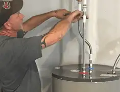 Water heater repair technician tightening supply line connections in Nashville, TN
