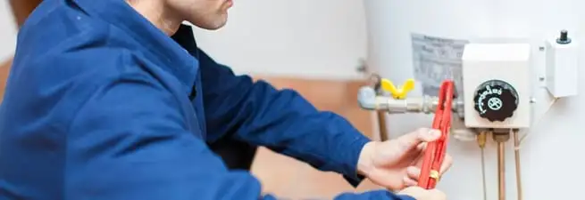 Water heater repair technician adjusting the temperature control and gas valve in Nashville, TN